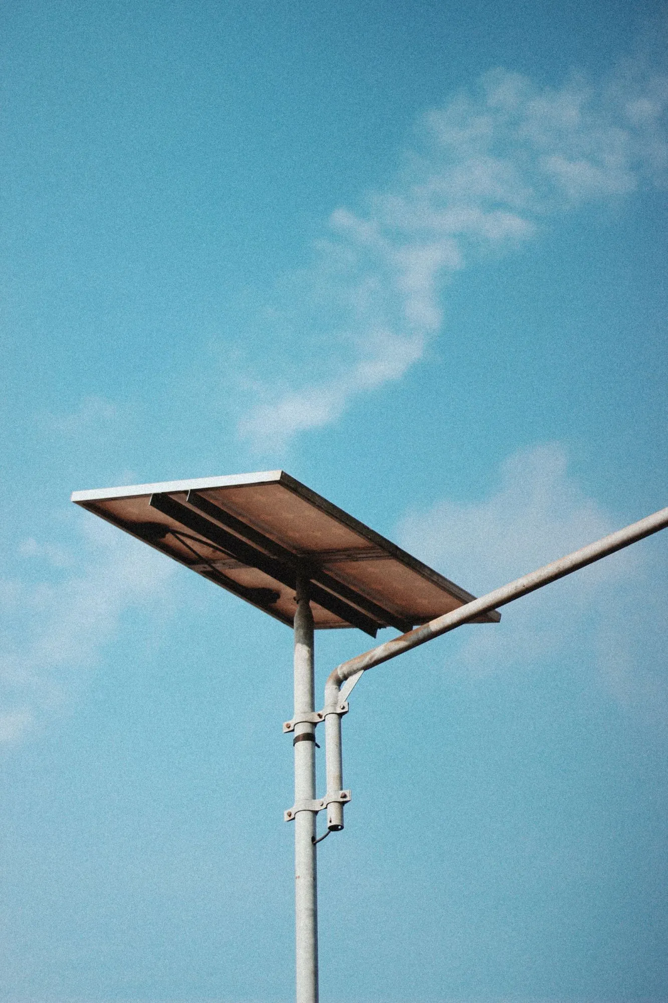 Solarpaneel auf einem Mast vor blauem Himmel